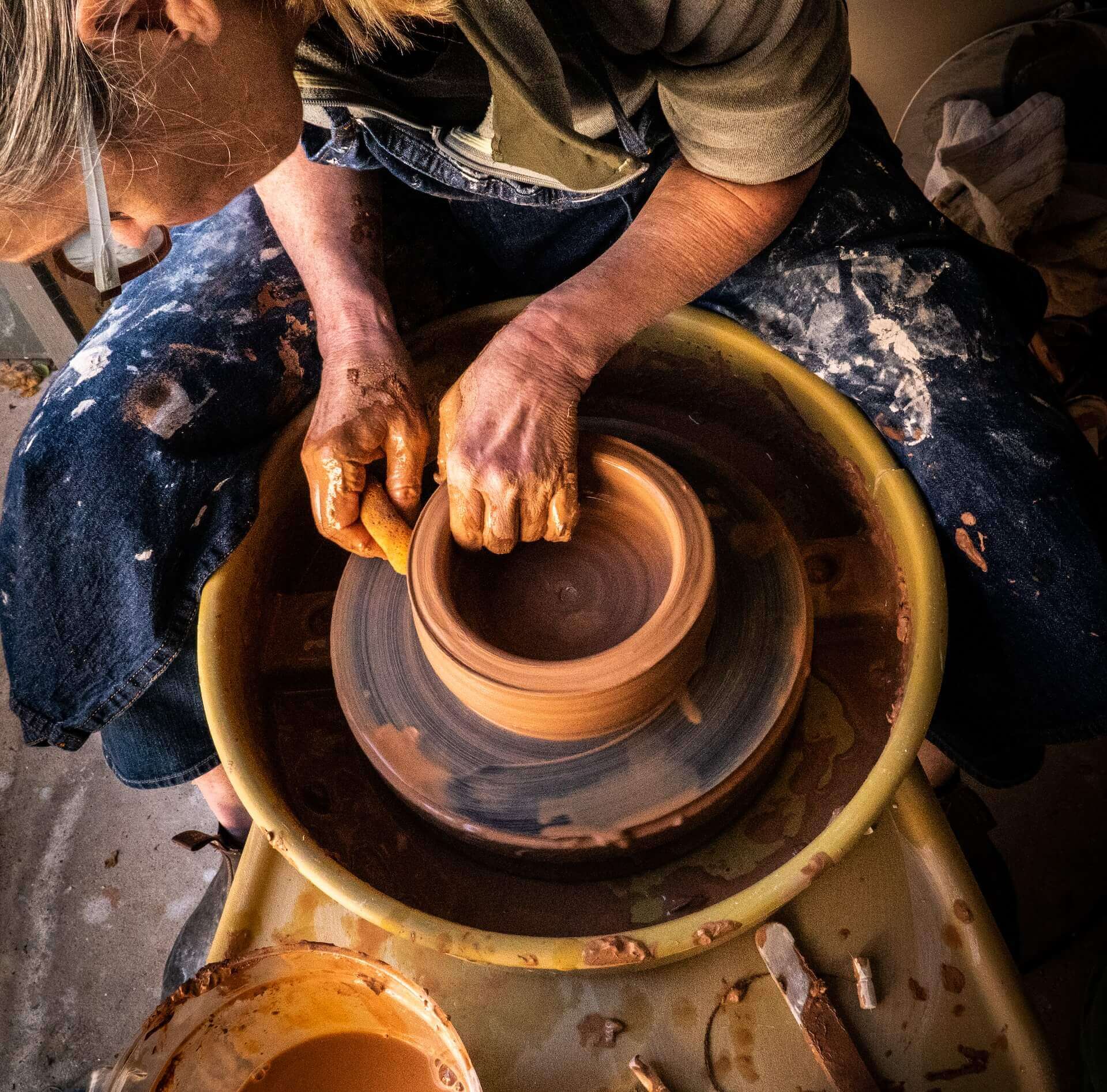 Person using pottery wheel and hands to making ceramic bowl